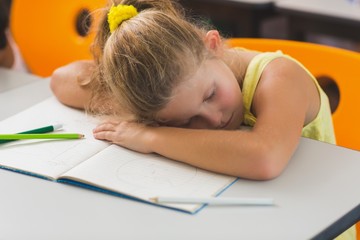 Schoolgirl sleeping at desk