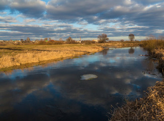 Thaw and melting ice on a small river in the outback of Belarus. Rural landscape/ 