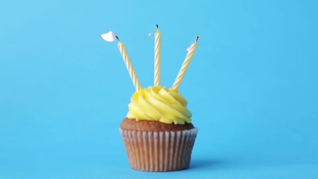 birthday cupcake with three burning candles