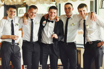 Groom and his friends pose in a restaurant