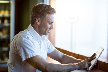 Man using digital tablet in café