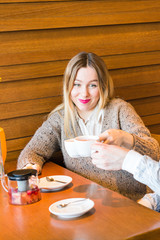 people, communication and dating concept - happy couple drinking tea at cafe or restaurant