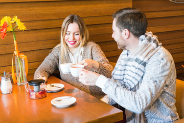 people, communication and dating concept - happy couple drinking tea at cafe or restaurant