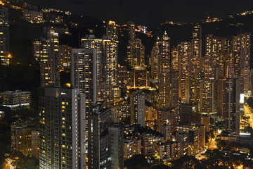 Crowded Hong Kong skyline scene at night with tightly packed skyscrapers and apartment buildings