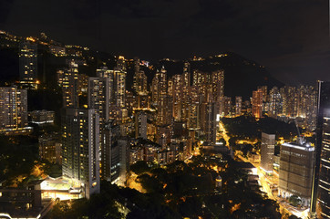 Fototapeta premium Crowded Hong Kong skyline scene at night with tightly packed skyscrapers and apartment buildings