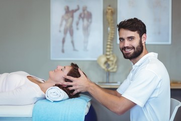 Physiotherapist giving head massage to a woman