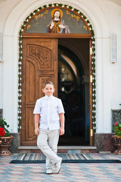 Portrait of little boy on white wear and bow tie on first holy c