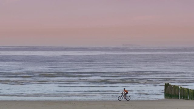 vtt(fate bike)  sur la plage au coucher du soleil