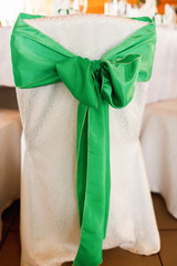 Big green bow dressed on a white chair