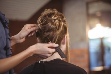 Female hairdresser styling customers hair