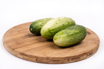 Fresh cucumbers on the round cutting board