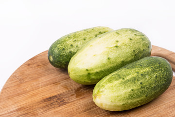 Fresh cucumbers on the round cutting board