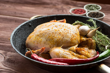 Whole roasted chicken with vegetables in cast-iron pan