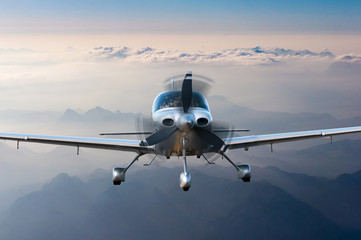 Naklejka premium Prywatny samolot lekki lub samolot leci na tle gór. Koncepcja podróży VIP
