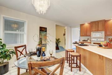 Dining area with glass table and tile floor.