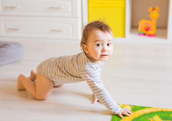 Adorable baby boy in bedroom.