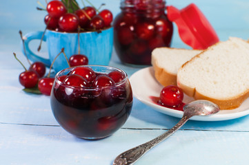 delicious cherry jam and toast bread. On a blue wooden surface.
