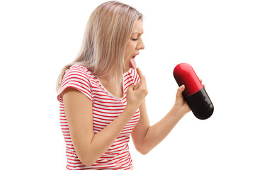 Sick young woman holding a pill