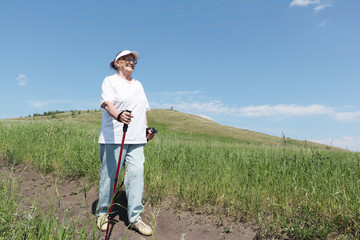 Nordic Walking - elderly woman is hiking