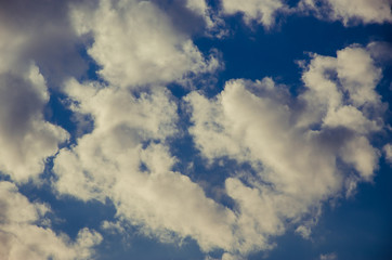 cumulus clouds float across the blue sky
