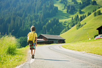 Cute little child with backpacks travel on the road to scenic mo