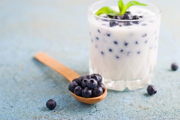 Fototapeta na wymiar Homemade yogurt with fresh blueberries on a wooden table,selective focus