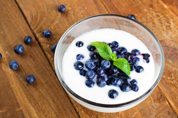 Homemade yogurt with fresh blueberries on a wooden table
