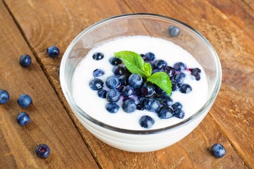 Homemade yogurt with fresh blueberries on a wooden table