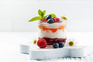  dessert with jam, cream and fresh fruit in a glass jar on white © cook_inspire
