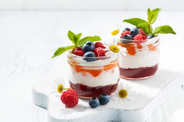 Zelfklevend Fotobehang dessert with jam, cream and fresh fruit in a glass jars  © cook_inspire