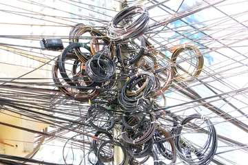 Fotobehang Choas, Messy, Tangle of electric cable post in Thailand © aphichetc