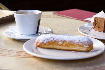 Chocolate cakes and a cup of coffee with a menu at a table in a restaurant.