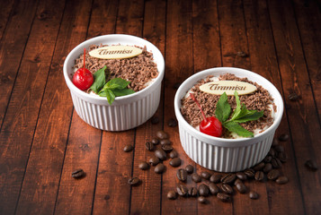 Tiramisu dessert on wooden background, with chocolate, decorated by cherry and mint