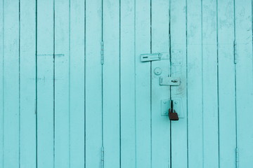 Blue old town wooden door locked with old padlock