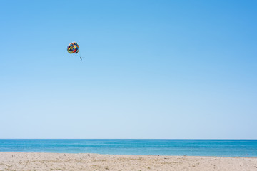 Parasailing summer sport. Parachute and boat. High in the sky over the sea.