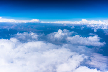 Fototapeta na wymiar Clouds with blue sky high above the ground photo from airplane
