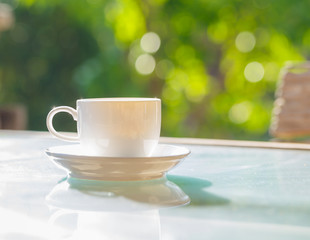 Obraz na płótnie Canvas cup of coffee on table in green garden