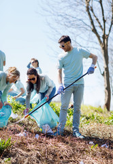 volunteers with garbage bags cleaning park area