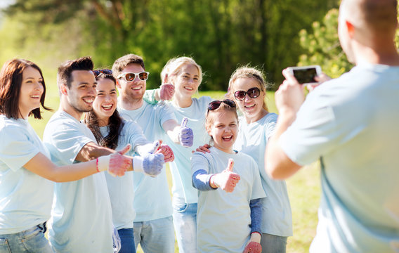 group of volunteers taking picture by smartphone