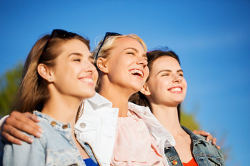 happy women or teenage girls hugging outdoors