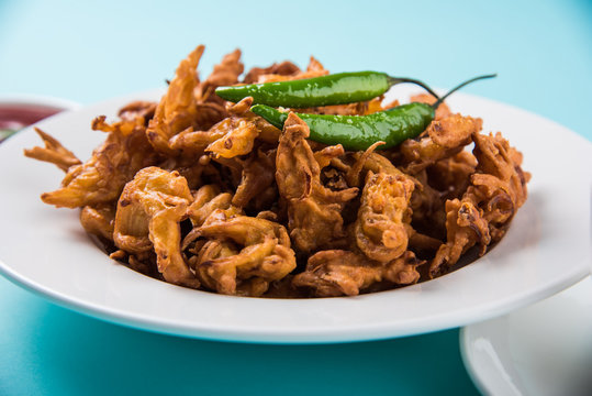 Crispy onion bhaji or kanda bhaji or fried onion pakore or pakode, delicious street food, favourite indian snack in monsoon served with hot tea