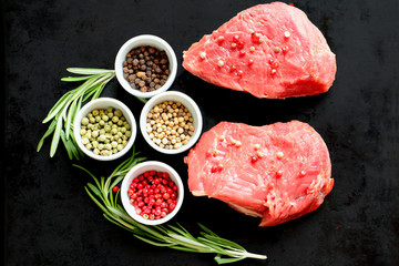 Raw red meat ready for pepper steak cooking  with rosemary and colored peppers - black, rose, green (pepe verde) and white