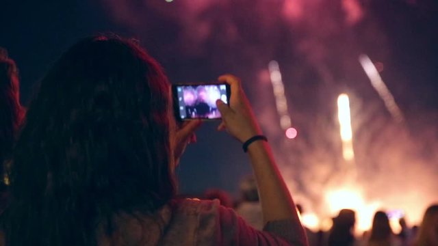Man filming colorful fireworks on his cell phone. HD.