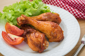 Grilled chicken legs and vegetables on plate