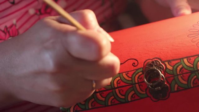 paints with a brush on wood