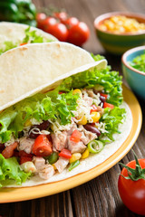 Mexican tacos with meat, beans, lettuce, corn, onion, tomato and 