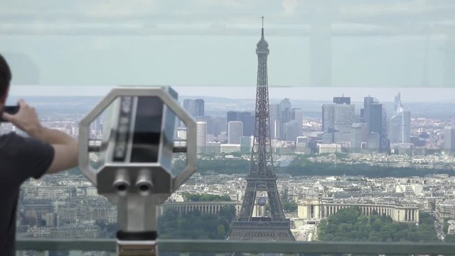 Man With Smartphone Takes Pictures Of Eiffel Tower From Montparnasse. The Montparnasse Tower Panoramic Observation Deck has the most beautiful view of Paris.