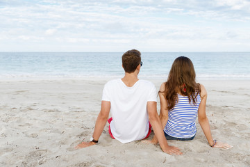 Romantic young couple sitting on the beach