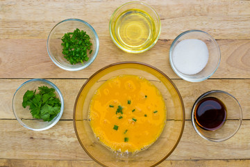 Raw eggs and ingredients on  wooden background. Vegetarian food, health or cooking concept.