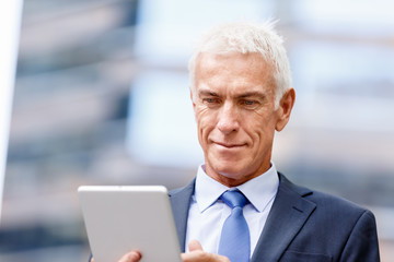 Senior businessman holding touchpad 